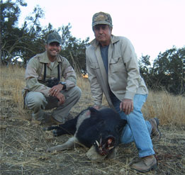two hunters with a hog
